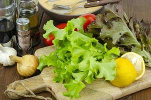 lettuce leaves on wooden cutting board, set of spices for cooking. Studio Photo. photo