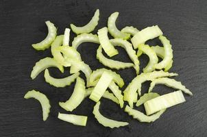 Slices of fresh raw celery stalk on black background. photo