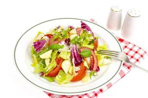 Plate with lettuce, tomatoes, olive oil. Vegetarian menu. photo