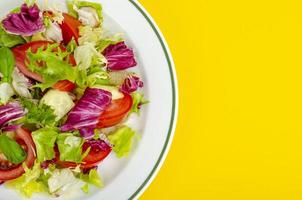 Light dietary vegetarian salad in plate on bright background. Healthy lifestyle concept