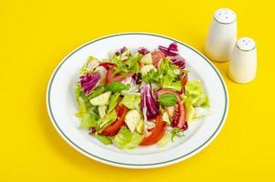 Light dietary vegetarian salad in plate on bright background. Healthy lifestyle concept photo