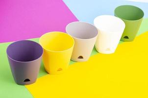 Bright blank flower pots on color paper background. photo