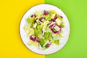 Light dietary vegetarian salad in plate on bright background. Healthy lifestyle concept photo