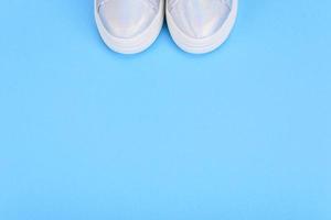 Silver sneakers on a blue background with place for text photo