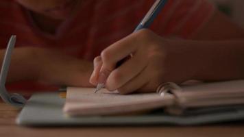 Close-up of the hand of a little girl writing on a notebook. video