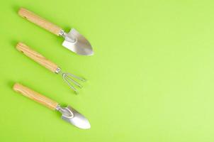 Gardening tools on green background. Gardening concept composition. View from above photo