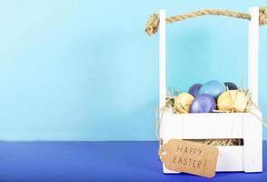Colorful background with Easter eggs on blue background. Happy Easter concept. Can be used as poster, background, holiday card. Flat lay, top view, copy space. Studio Photo