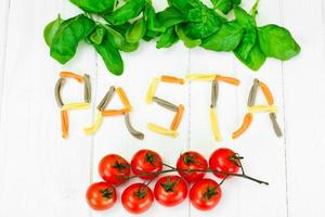 Basil, Red Cherry Tomato with Pasta on White Woody Background photo
