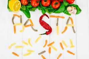 Basil, Red Cherry Tomato with Pasta on White Woody Background photo