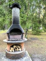 Barbecue stove with wood, playground, trees, picnic area. photo