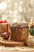 Chocolate panettone  on wooden table with christmas ornaments photo