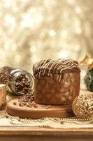 Panettone de chocolate sobre mesa de madera con adornos navideños foto