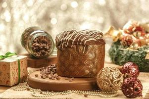 Chocolate panettone  on wooden table with christmas ornaments photo