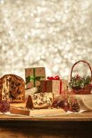 Rebanada de panettone de chocolate sobre tabla de cortar de madera con adornos navideños foto