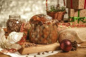 Panettone de chocolate sobre mesa de madera con adornos navideños foto