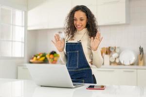 Latin woman shooting video and cooking at the kitchen photo