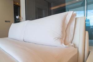 Decoración de almohadas cómodas blancas en la cama foto