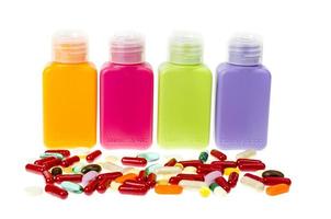 Multi-colored plastic bottles, containers with pills and capsules isolated on white background. photo