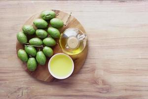 Botella de aceite de oliva y aceitunas frescas en la mesa
