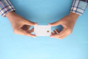 top view of hand hold a credit card on blue background photo