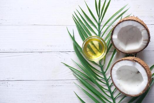 top view of slice of fresh coconut and bottle of oil on a table photo