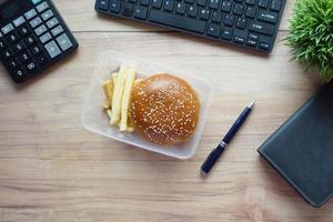 beef burger and french friend in a lunch box on office desk photo