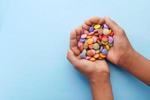 Niño niño recogiendo caramelos dulces multicolores vista superior foto