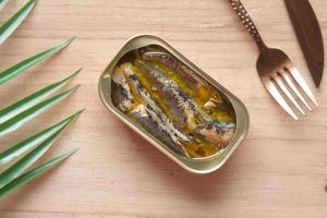 open tin of sardines on white tiles background. photo