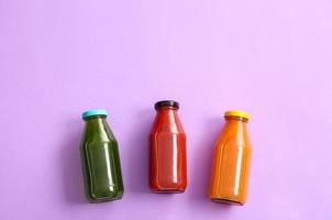 Bottles with healthy juice on color background photo