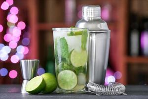 Glass of fresh mojito on table in bar photo