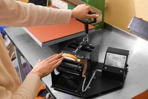 Young woman printing on cup at workshop photo