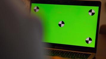 mulher sentada à mesa com videochamada com tela verde video