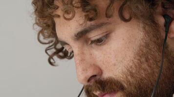 Close up of man with earplugs watching screen video