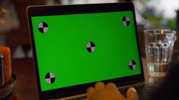 man typt op laptop met groen scherm video