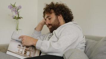 Man on couch reading magazine video