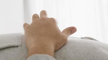 Close up of moving fingers and man lying on his back listening to music with closed eyes video