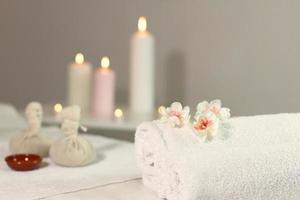 Warm herbal massage table with towels and candles