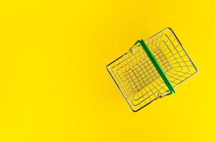Shopping basket on a bright yellow background with an empty place for an inscription. photo