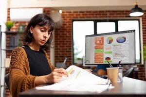 Businesswoman analyzing marketing graph working at company strategy in startup office photo