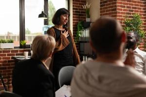 Impressed woman receiving applause from group of people at aa meeting program