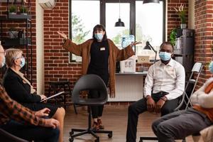Woman with face mask talking about problems at aa group meeting photo