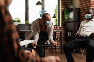 Man with face mask talking to group at aa meeting program about health issues