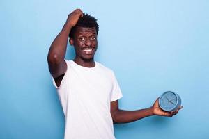 Portrait of man with wall clock holding hand on head photo