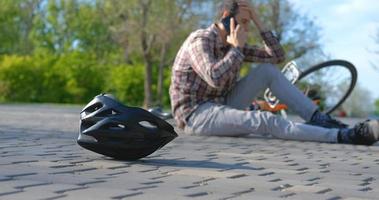 Young male in casual clothes fell from the bicycle in the park photo