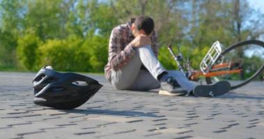 Young male in casual clothes fell from the bicycle in the park photo