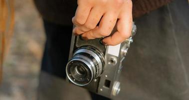 close up of old film camera in woman hand