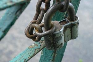 Old gray padlock on a chain. Vintage lock close up. photo