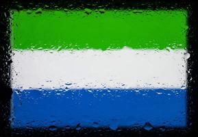 Drops of water on sierra leone flag background. Shallow depth of field. Selective focus. Toned. photo