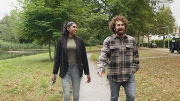 hombre y mujer caminando y hablando en el parque video
