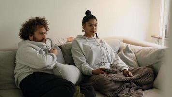 Man and woman sitting on sofa talking and watching television video